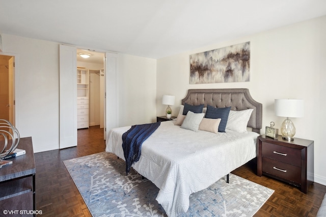 bedroom with dark parquet floors, a closet, and a spacious closet