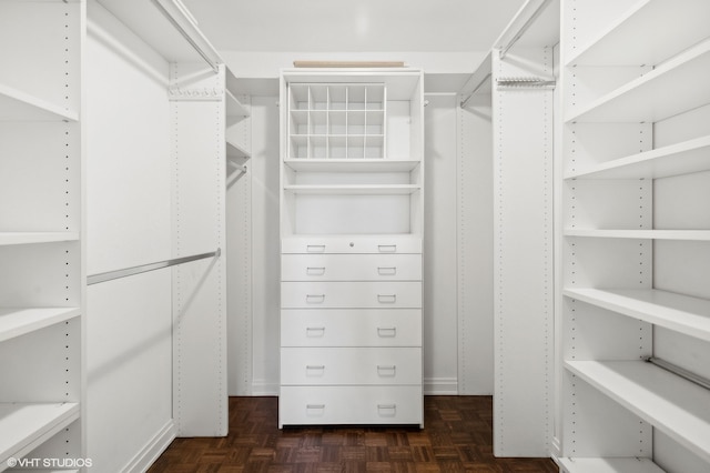 spacious closet with dark parquet floors