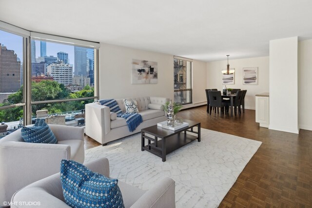 living room featuring expansive windows, a baseboard heating unit, and parquet floors