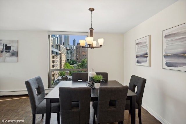 dining space with dark parquet floors, baseboard heating, and a chandelier