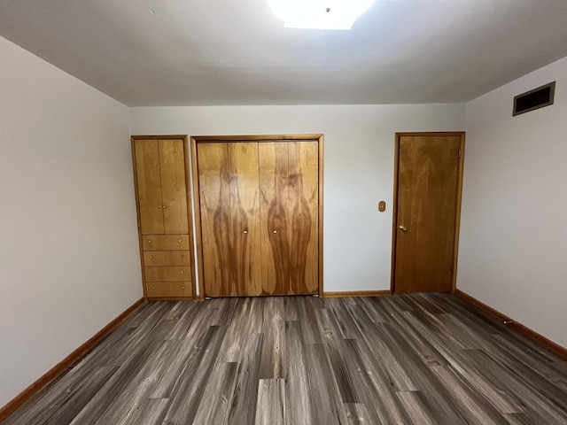 unfurnished bedroom with dark hardwood / wood-style floors and a closet