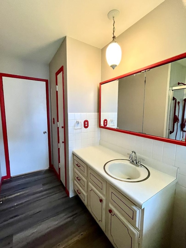 bathroom with hardwood / wood-style floors, vanity, and tile walls