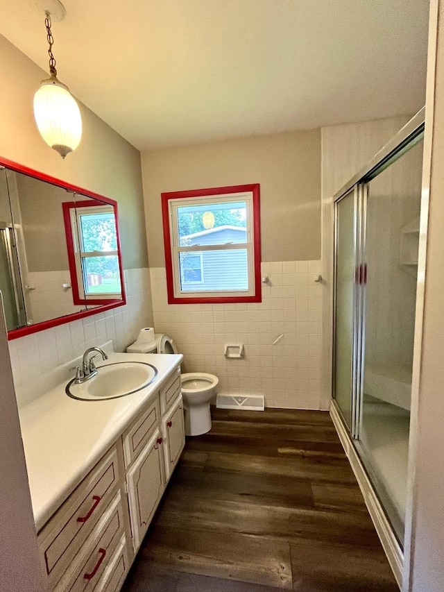 bathroom with wood-type flooring, vanity, plenty of natural light, and tile walls