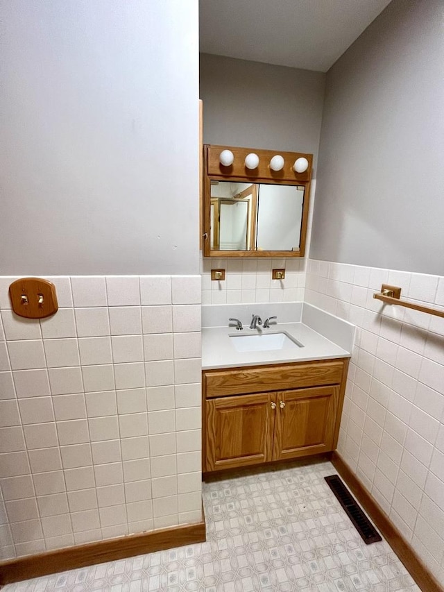 bathroom with vanity and tile walls