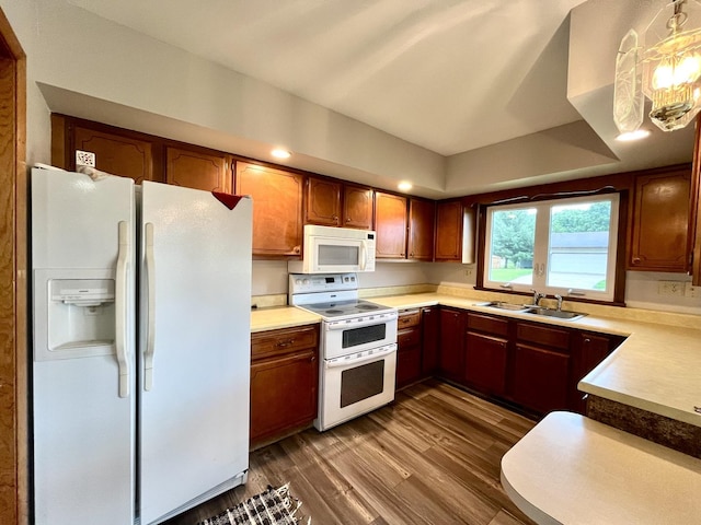 kitchen featuring dark hardwood / wood-style flooring, sink, decorative light fixtures, and white appliances