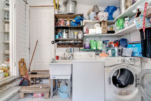 clothes washing area featuring separate washer and dryer and sink