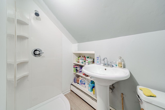 bathroom with walk in shower, toilet, vaulted ceiling, and a baseboard heating unit