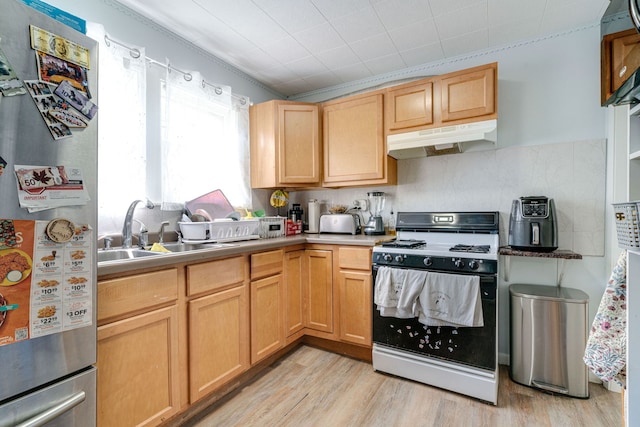 kitchen with sink, light hardwood / wood-style flooring, stainless steel refrigerator, white range with gas stovetop, and light brown cabinets