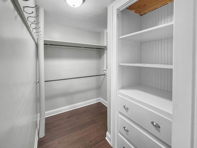 walk in closet with dark wood-type flooring