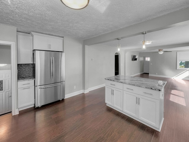 kitchen with stainless steel refrigerator, white cabinetry, and dark hardwood / wood-style floors