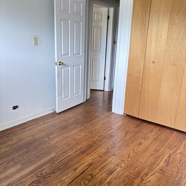 137 Julie Dr, Glenview, IL 60025 - unfurnished bedroom featuring dark wood-style flooring, baseboards, and a closet
