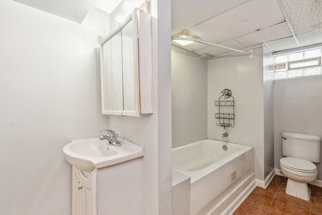 full bathroom with bathing tub / shower combination, toilet, a drop ceiling, tile patterned floors, and vanity