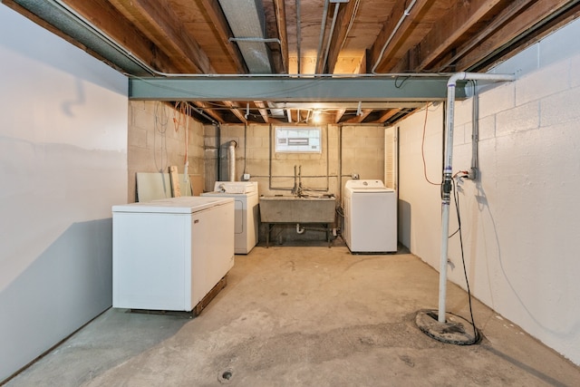 basement featuring sink, refrigerator, and separate washer and dryer