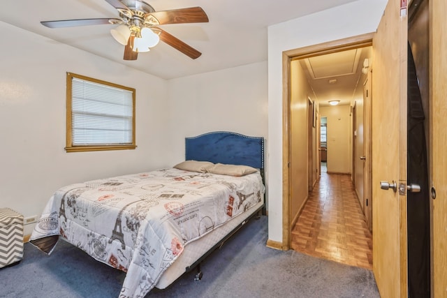 bedroom featuring parquet flooring, ceiling fan, and multiple windows