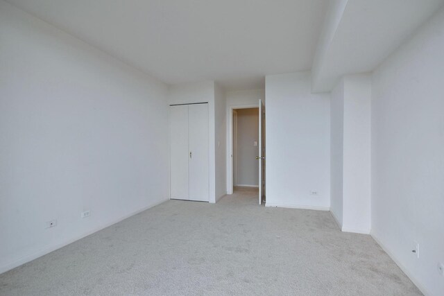 unfurnished room featuring light carpet