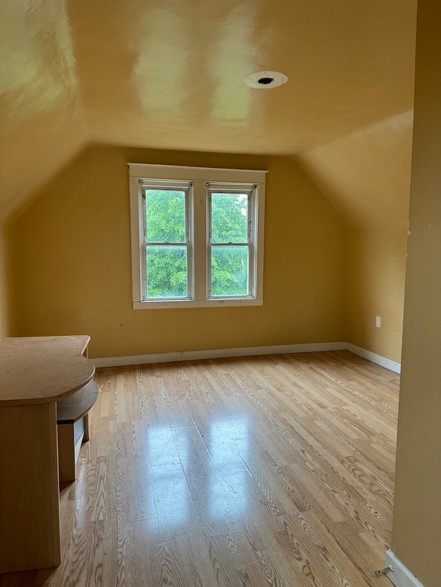 bonus room with lofted ceiling and light hardwood / wood-style flooring