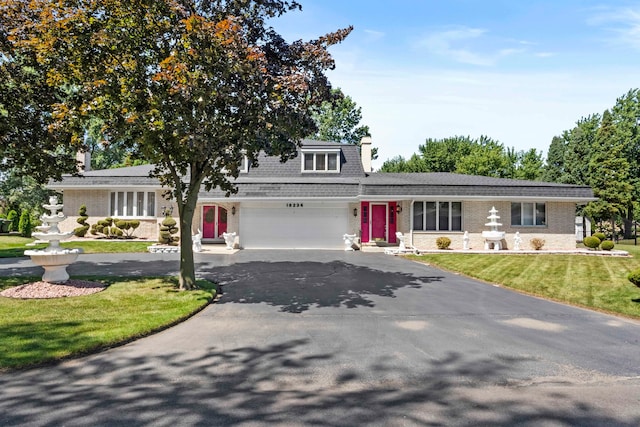 view of front of house with a garage and a front lawn