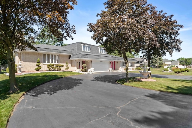 view of front of home with a garage and a front lawn