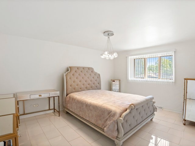 bedroom with a notable chandelier and light tile patterned floors