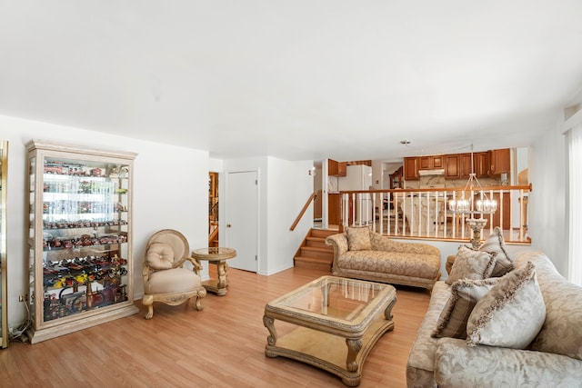 living room with light hardwood / wood-style flooring and an inviting chandelier