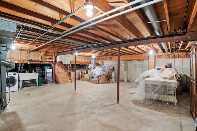 basement featuring sink and washer / dryer