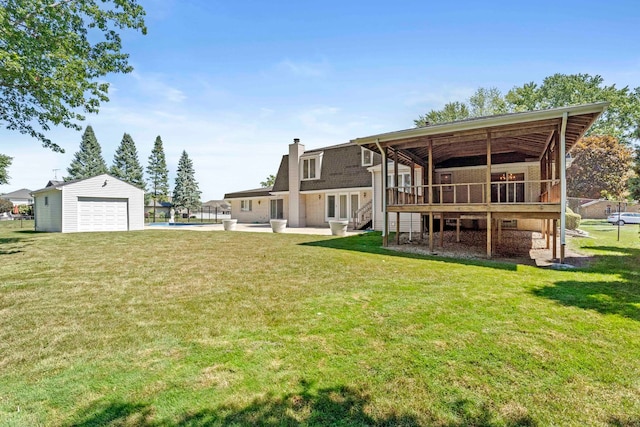 back of property featuring a pool side deck, a yard, a garage, and an outdoor structure