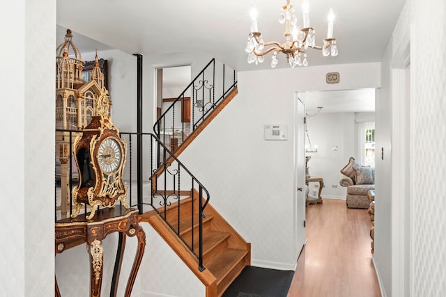 stairway featuring hardwood / wood-style flooring and a chandelier