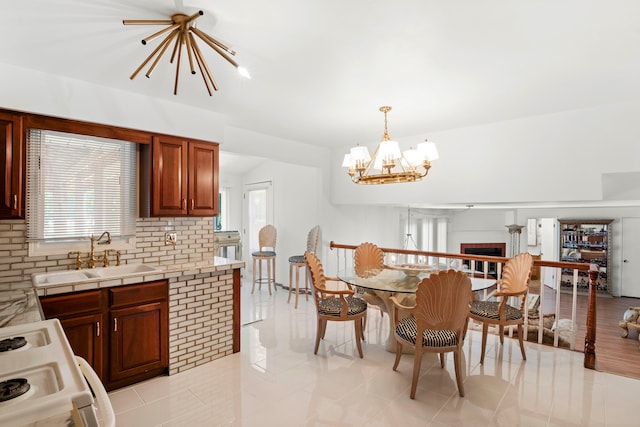 tiled dining room featuring sink and an inviting chandelier