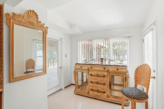 sitting room featuring lofted ceiling, plenty of natural light, and light tile patterned floors