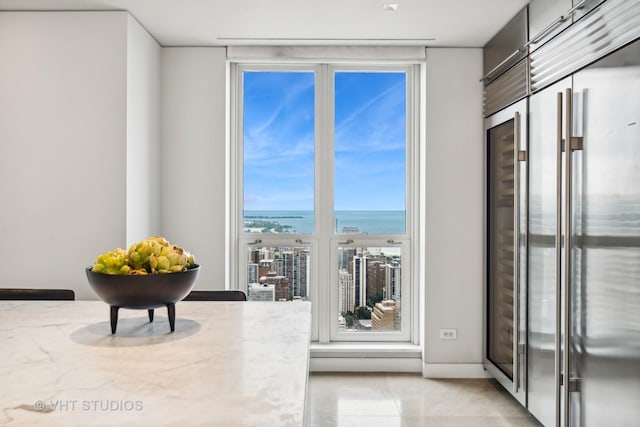 interior space featuring a water view and light tile patterned floors