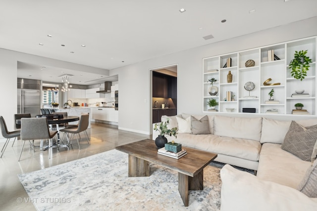 living room featuring sink, light tile patterned flooring, and an inviting chandelier