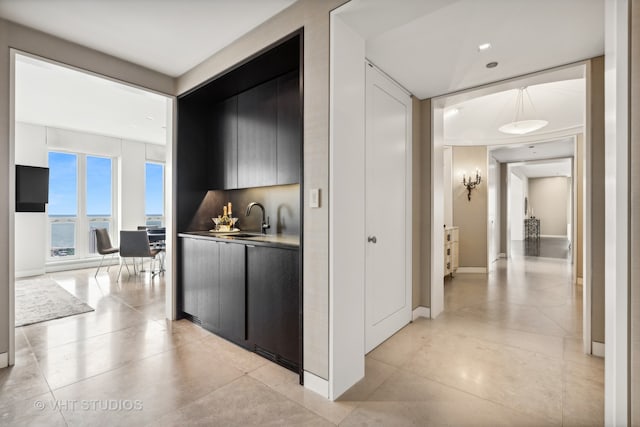 corridor featuring light tile patterned flooring and sink