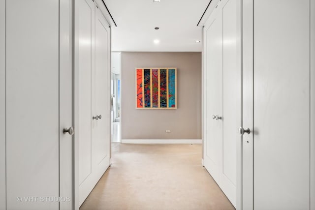 hallway with recessed lighting and baseboards