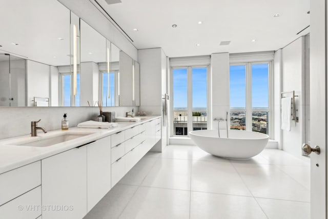 full bathroom with tile patterned flooring, a freestanding tub, a sink, and double vanity