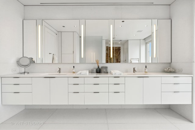 bathroom with dual bowl vanity and tile patterned flooring