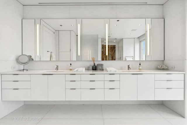 bathroom featuring a shower, a sink, and double vanity