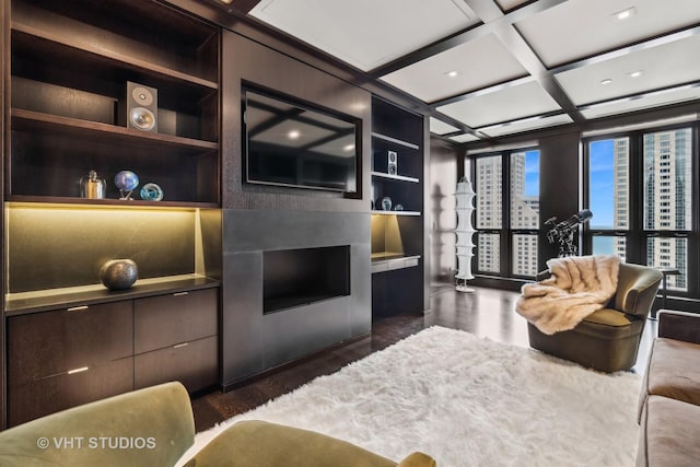 living room with built in shelves, coffered ceiling, and dark wood finished floors