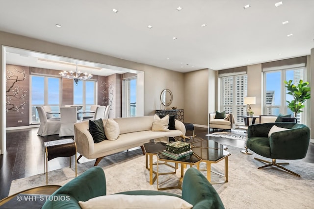 living room with recessed lighting, baseboards, an inviting chandelier, and wood finished floors