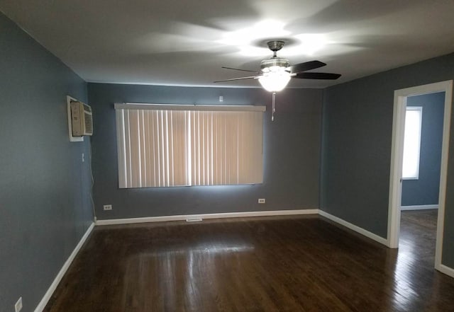 spare room featuring ceiling fan, wood-type flooring, and a wall unit AC