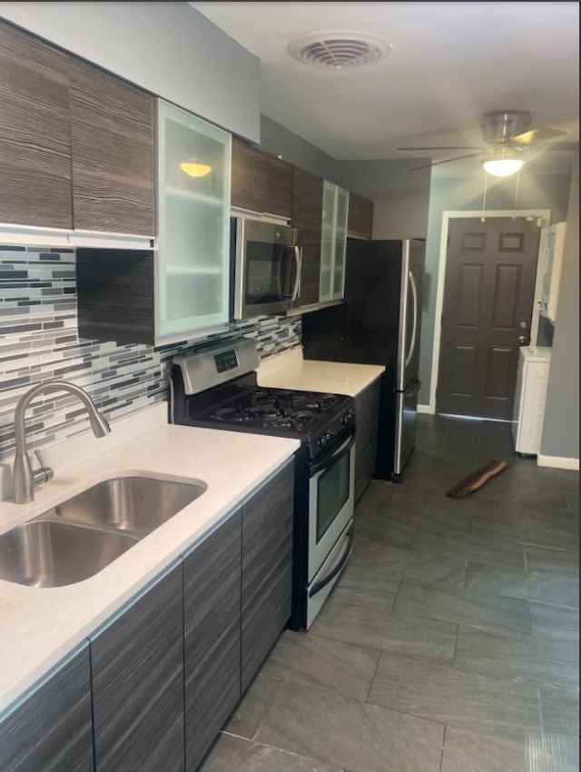 kitchen featuring appliances with stainless steel finishes, sink, tasteful backsplash, and ceiling fan