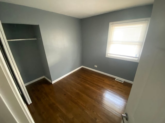 unfurnished bedroom with a closet and wood-type flooring