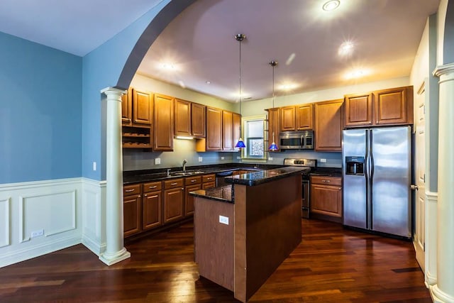 kitchen featuring pendant lighting, dark hardwood / wood-style floors, a center island, and appliances with stainless steel finishes