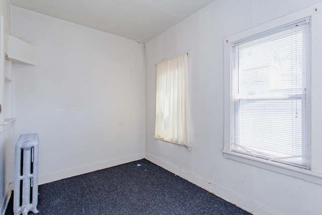 carpeted spare room featuring radiator