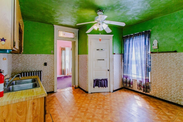 kitchen featuring sink, radiator heating unit, and ceiling fan