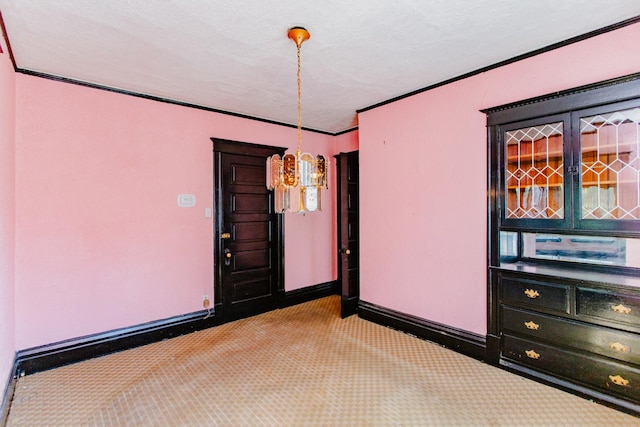 carpeted empty room featuring crown molding, a chandelier, and a textured ceiling