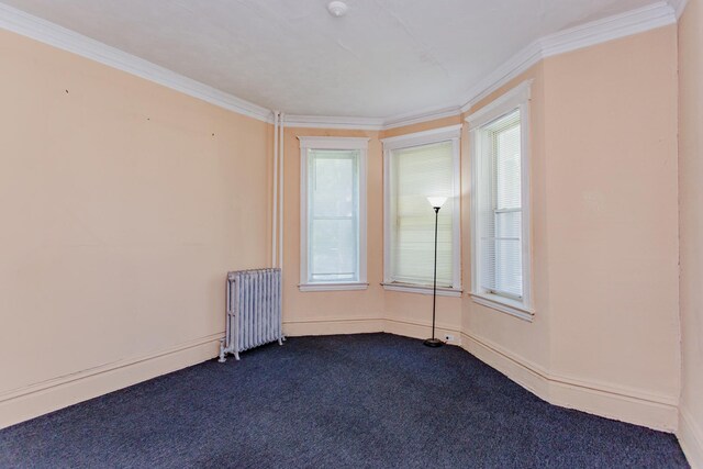 carpeted empty room with radiator, plenty of natural light, and crown molding