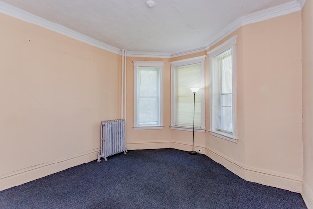 unfurnished room with dark colored carpet, ornamental molding, radiator heating unit, and a wealth of natural light