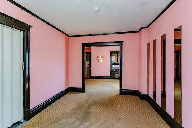 hall featuring crown molding, carpet floors, and a textured ceiling