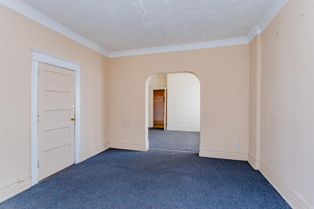 empty room featuring ornamental molding and dark carpet