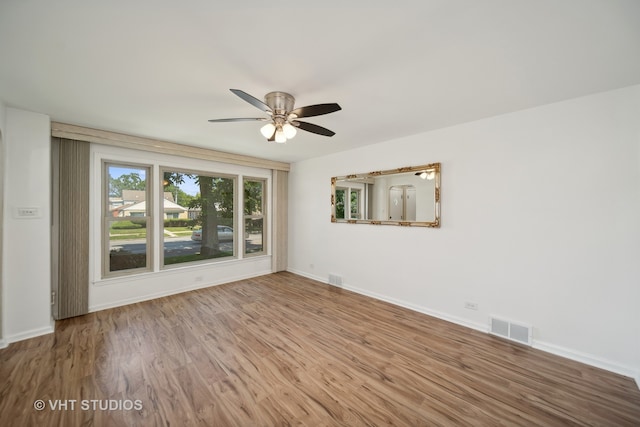 empty room with ceiling fan and light hardwood / wood-style floors